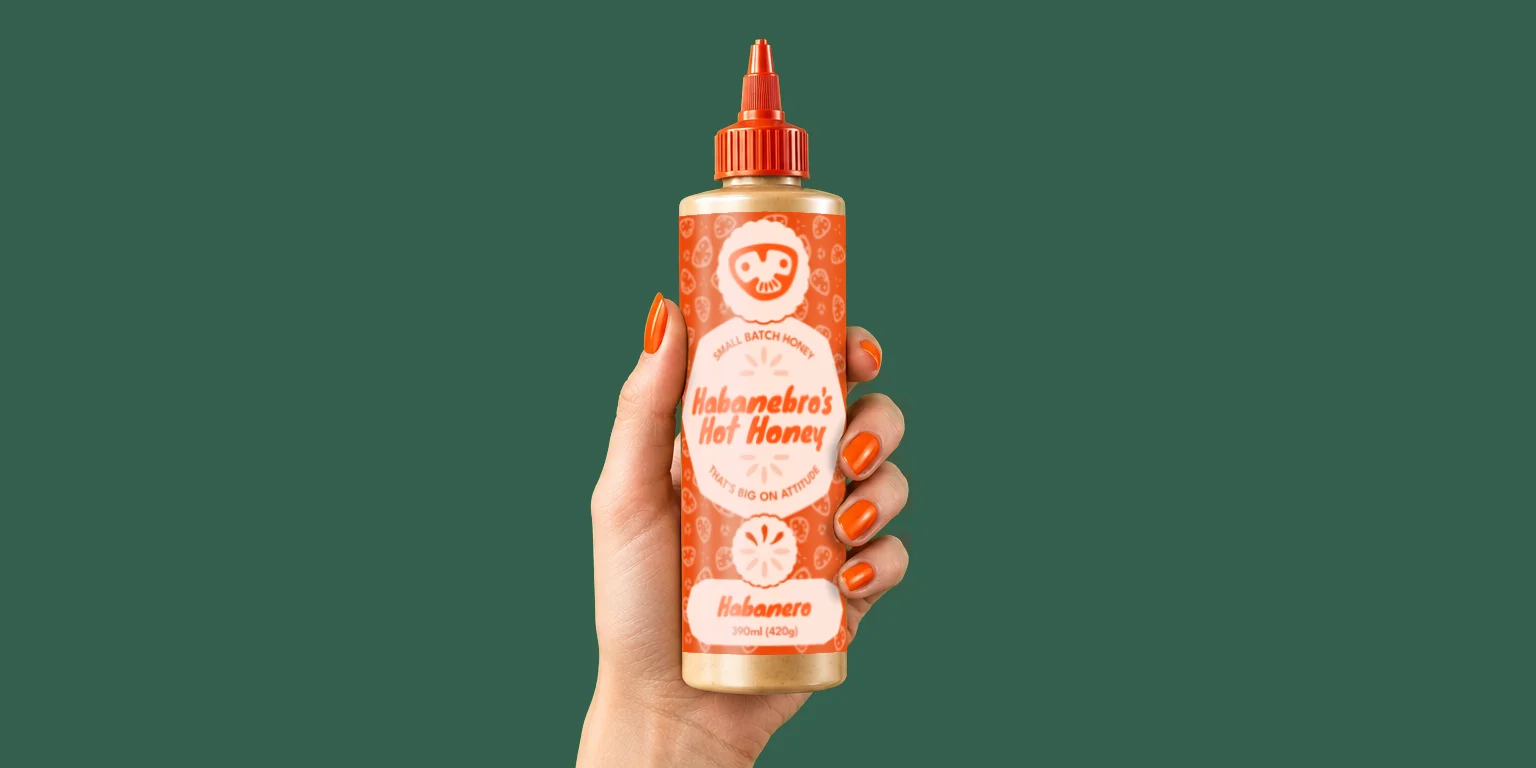 Habanebro's Honey bottle held in a woman's hand, on deep green background
